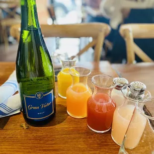 a bottle of champagne and glasses of juice