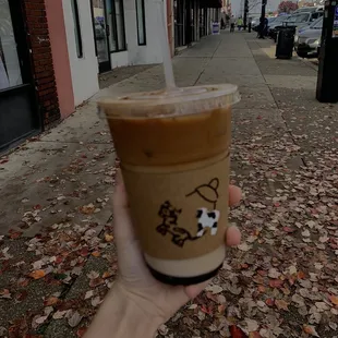 a hand holding a cup of iced coffee