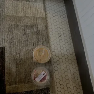 two containers of coffee on the floor