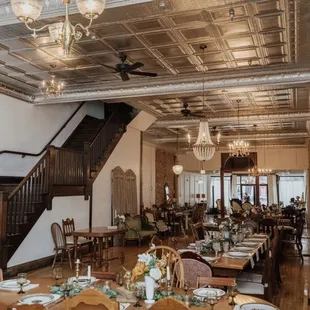 The gorgeous tin ceiling shines with the light from the chandeliers.