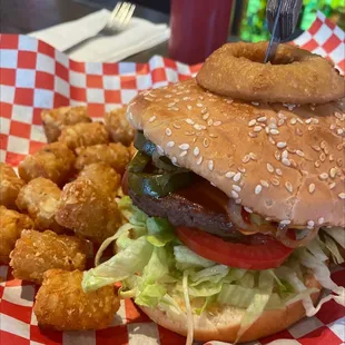 a burger with onion rings and lettuce