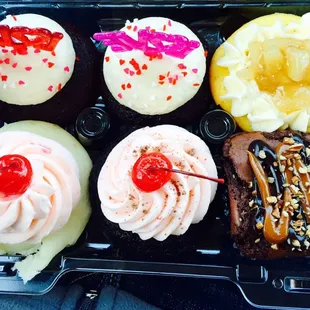 a variety of cupcakes in a plastic container
