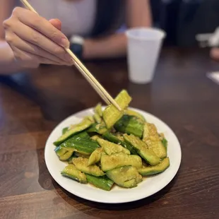 a plate of stir fried zucchini with chopsticks
