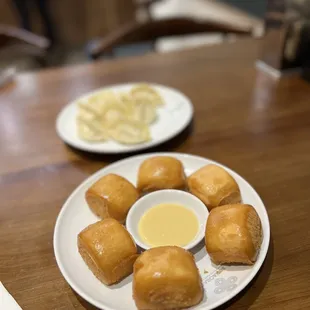 a plate of doughnuts and a bowl of dipping sauce