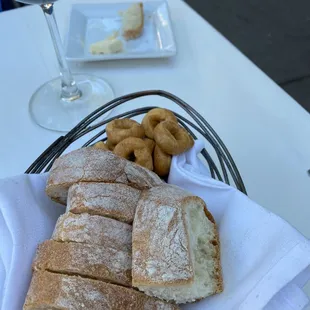 a basket of bread and a glass of red wine