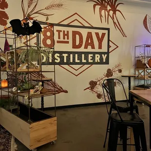 tables and chairs in front of a sign that says 9th day distillery