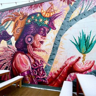 a mural of a woman holding a plant