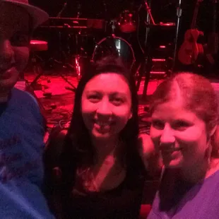 a man and two women standing in front of a stage