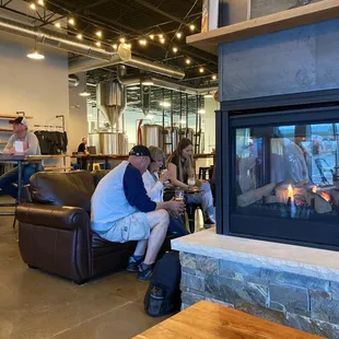a man and a woman sitting in front of a fireplace