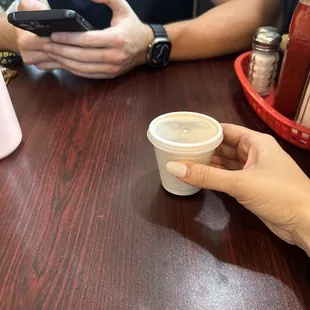 two people sitting at a table with their cell phones