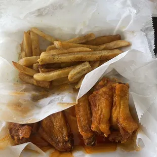a basket of chicken wings and french fries