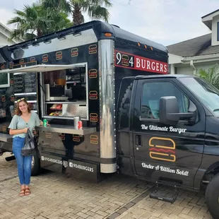 a woman standing in front of a food truck