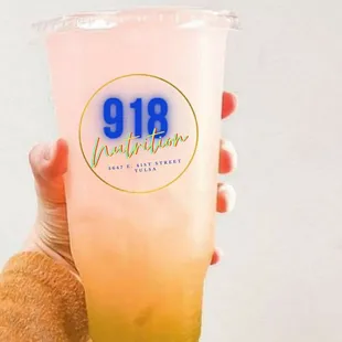 a hand holding a pink drink