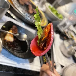 a person holding a fork with a piece of meat on it