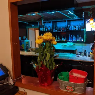 a vase of flowers in front of a bar