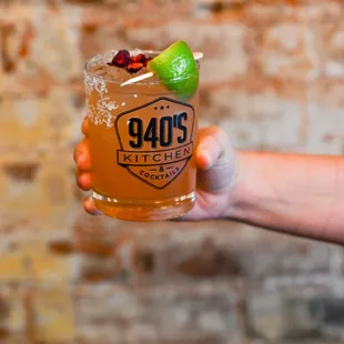 a hand holding a glass of cocktail