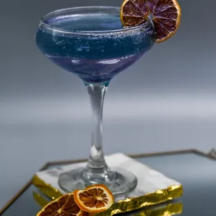 a blue cocktail with orange slices