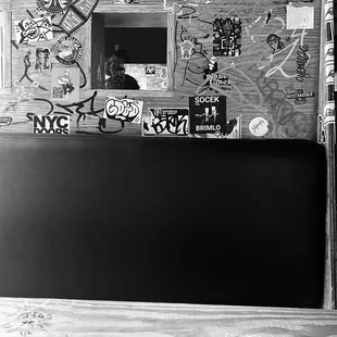 a black and white photo of a wall covered in stickers