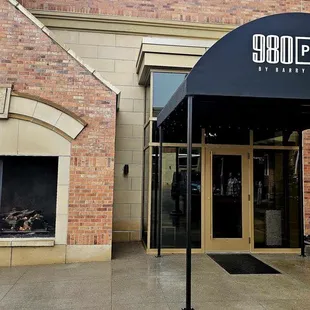 Entrance to the left of the hotel entrance.
