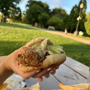 a hand holding a sandwich