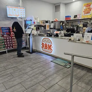 a man standing at the counter of a fast food restaurant