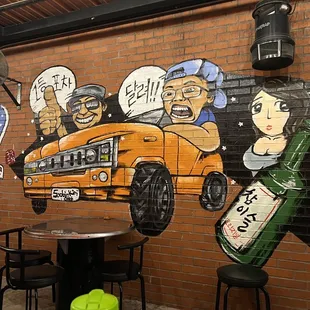 a brick wall with a mural of a school bus
