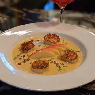 Seared Scallops served over butternut squash bisque with pink lady apples, pepitas, pomegranate &amp; Full-Hand microgreens