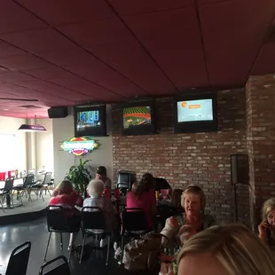 people sitting at tables and watching televisions