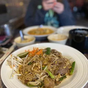 a woman taking a picture of a plate of food