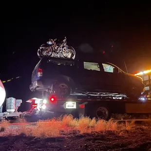 Our truck on the flatbed tow truck with our trailer hooked to the rear hitch