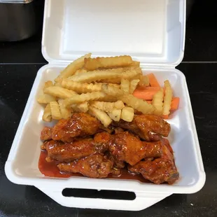 chicken wings and fries in a styrofoam container