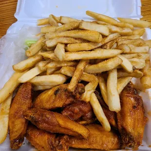 chicken wings and fries in a styrofoam container