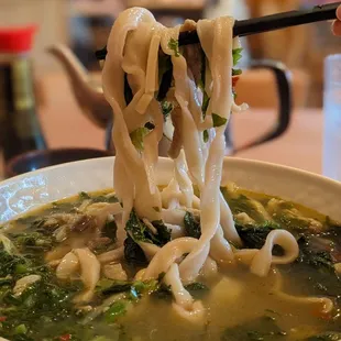 Shredded pork and mustard green noodle soup with wide noodles