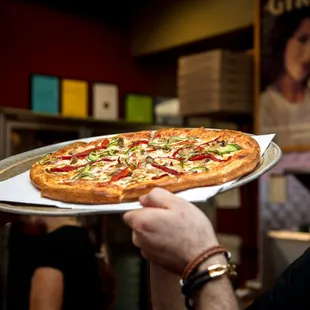 a man holding a pizza