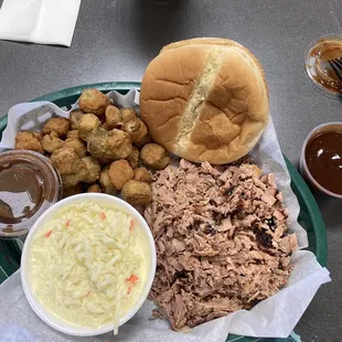 my meal of chopped pork shoulder, creamy coleslaw, breaded fried okra, and an extra cup of mild barbecue sauce (delicious feast)