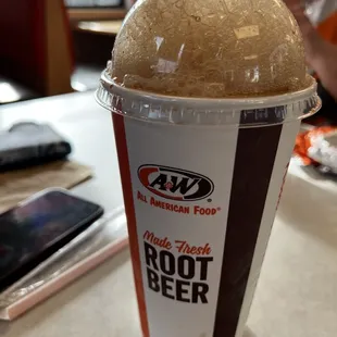 a cup of root beer on a table