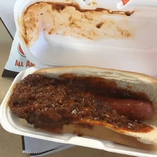 a chili dog in a styrofoam container