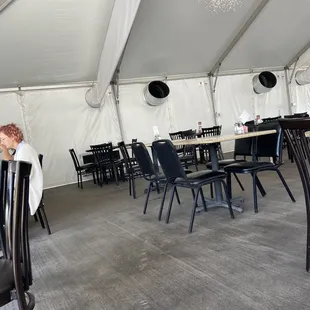 a man sitting at a table in a tent
