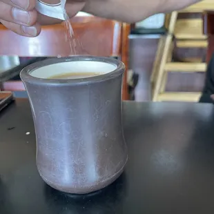 a person pouring something into a cup