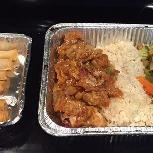 Orange chicken with rice, vegetables, and spring rolls