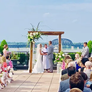 A wedding taking place on top of Frazier museum in downtown Louisville....The Ohio River and K &amp; I bridge in background...