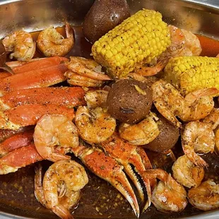 crab legs, corn, potatoes, corn on the cob