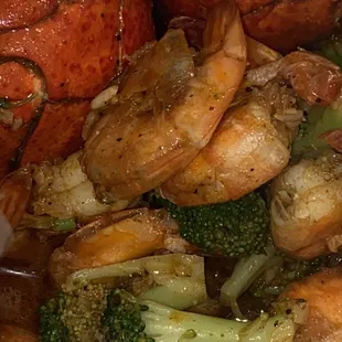 close up shrimp, lobster tail, and broccoli.