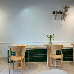 tables and chairs with a vase of flowers