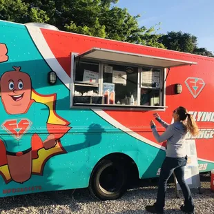 a woman standing in front of a food truck