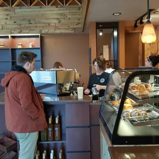 Espresso machine and pastries at the bar.