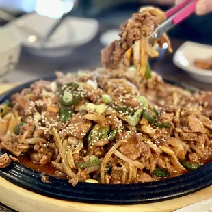 a plate of noodles with meat and vegetables