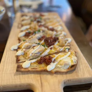a flatbread pizza on a cutting board