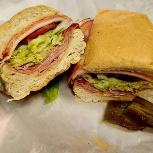 a cut in half sandwich and pickle