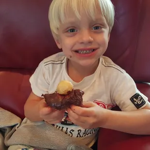  a young boy eating a donut